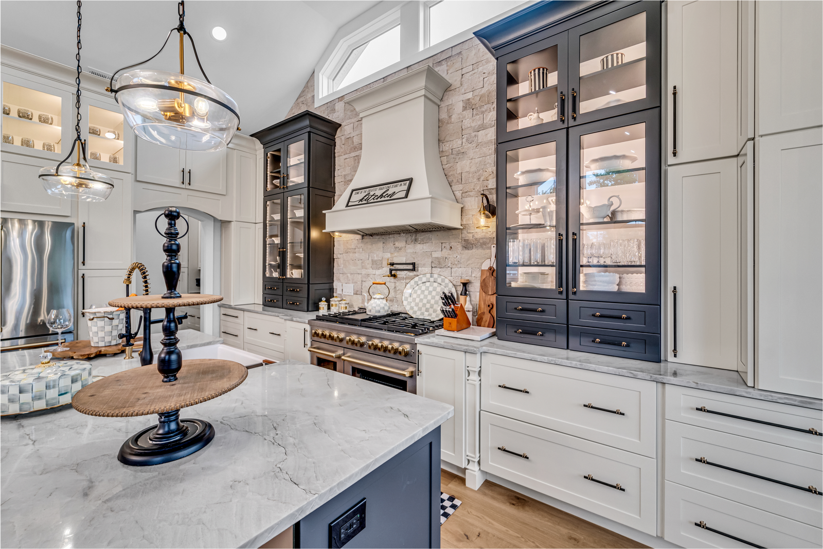 Open-concept kitchen with marble island and statement pendant lighting